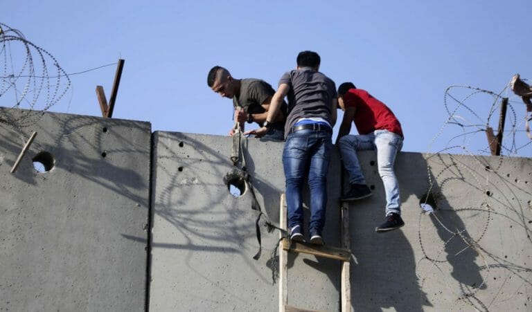 Palästinenser mit einer selbstgebastelten Leiter klttern über die israelische Sicherheitsmauer