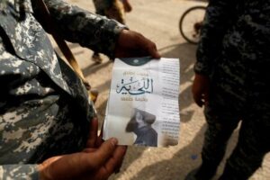 An Iraqi soldier shows a pamphlet which reads "Wearing beards is compulsory, shaving is prohibited" along a street of the town of al-Shura, which was recaptured from Islamic State (IS) on Saturday, south of Mosul, Iraq October 30, 2016. REUTERS/Zohra Bensemra/Files