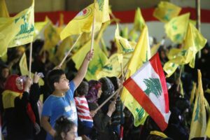 Während einer Rede von Hisbollah-Chef Hassan Nasrallah schwenken Anhänger im Libanon Fahnen der islamistischen Terrororganisation (imago images/Xinhua)