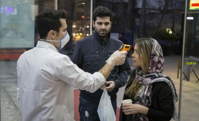 Mitarbeiter eines Einkaufszentrums in Teheran misst bei Kunden Fieber