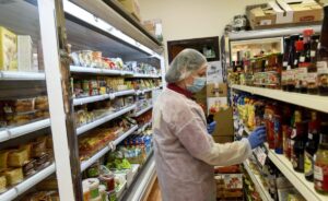 Mitarbeiterin eines israelischen Supermarktes trägt Corona-Schutzkleidung
