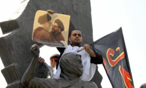 Demonstrant hält Plakat mit Irans oberstem Führer Khamenei und Hisbollah-Chef Nasrallah hoch
