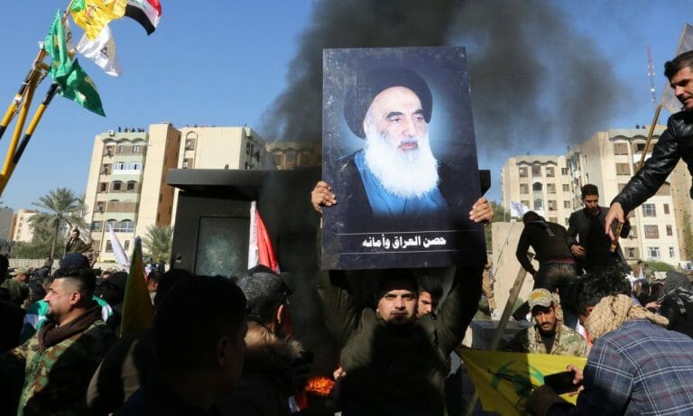 Mitglied der schiitischen PMU-Milizen mit einem Bild von Ayatollah al-Sistani