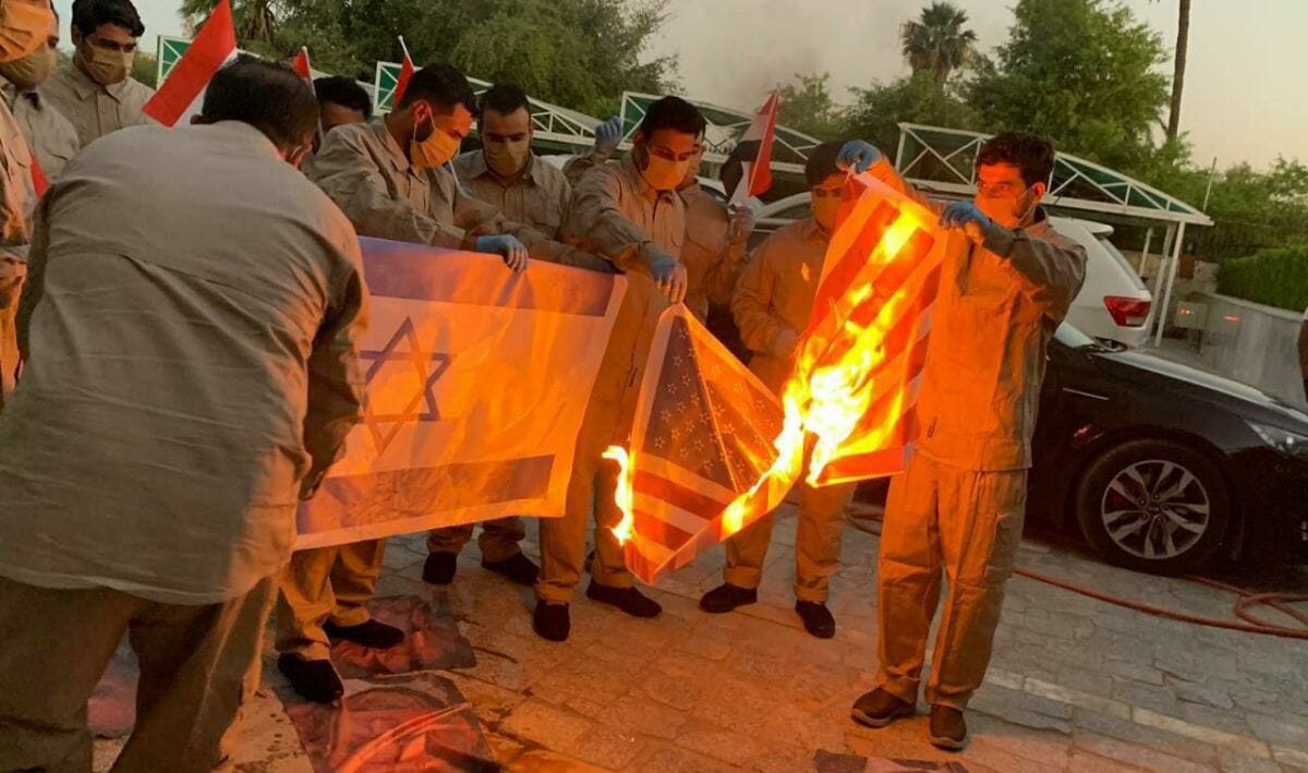 Mitglieder der pro-iranischen schiitschen Hisbollah-Kataib-Miliz zertrampeln Bilder des irakischen Premierministers und verbrennen Flaggen