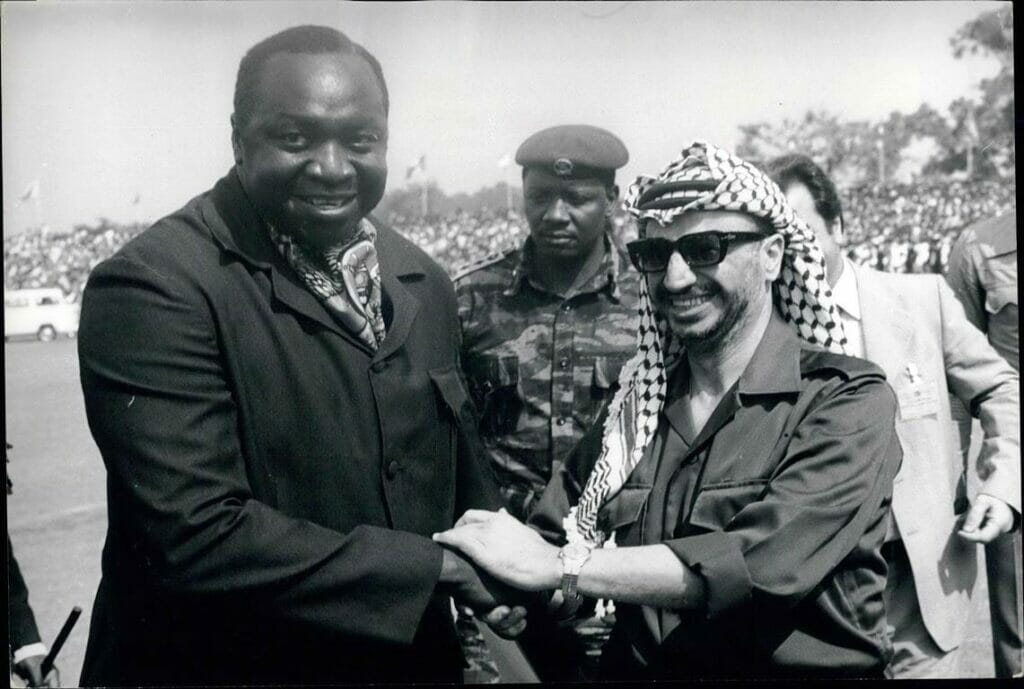 Ugandas blutrünstiger Diktator Idi Amin begrüßt 1975 PLO-Chef Arafat freudig am Flughafen von Entebbe. Ein Jahr später erlangt der Ort durch die israelische Operation gegen palästinensisch-deutschen Terror Berühmtheit. (© imago images/ZUMA/Keystone)