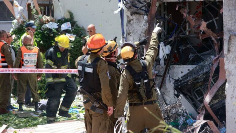 Israelische Rettungskräfte vor einem von einer Hamas-Rakete getroffenen Wohnhaus