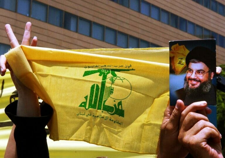 Flagge der Hisbollah, Bild von Hisbollah-Gegeneralsekretär Hassan Nasrallah. (© imago images/UPI Photo)