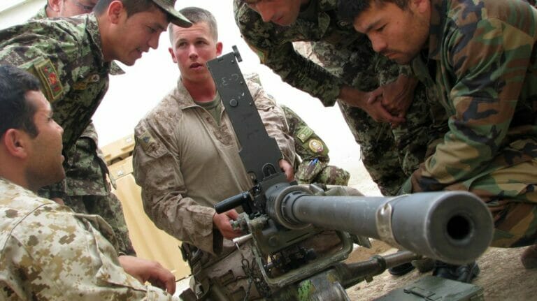 Ausbildner der US Marines schult afghanische Soldaten an einem Machinengewehr
