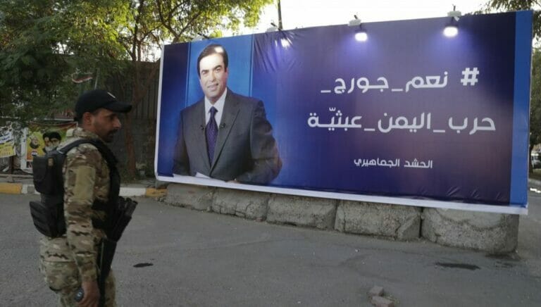 Schiitischer Milizionär vor einem Wahlplakat George Kordahis
