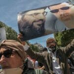 Demonstrant mit Palakt von Hisbollah-Führer Nasrallah und Syriens Diktator Assad