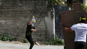 Palästinenser in Kfar Qaddum scheludern Steine gegen israelische Sicherheitskräfte
