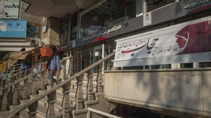 Iranerin missachtet Schild, das zum Tragen des Hidschabs bei Betreten eines Einkaufszentrums in Teheran auffordert