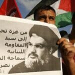 Ein Demonstrant der Terrororganisation Volksfront für die Befreiung Palästinas (PFLP) hält ein Plakat von Hisbollah-Chef Hassan Nasrallah