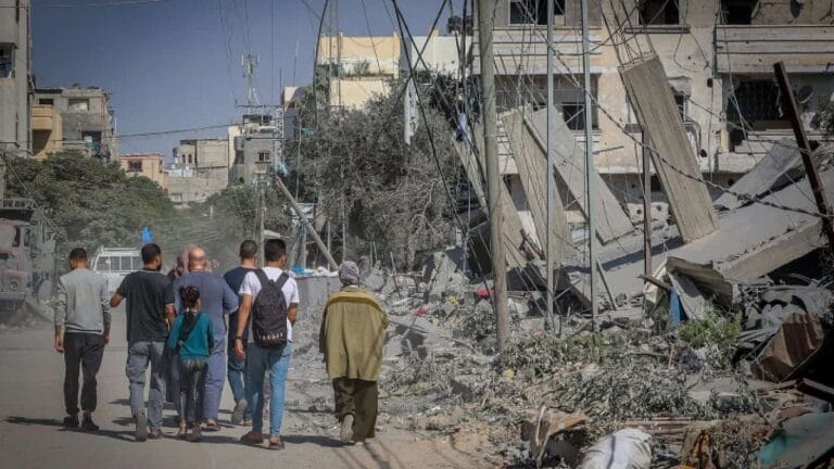 Palästinenser neben einem zerstörten Gebäude in Khan Younis im südlichen Gazastreifen