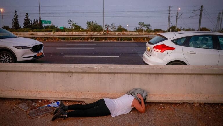 Israeli auf einer Straße im Zentrum des Landes geht vor einem Raketenangriff in Deckung